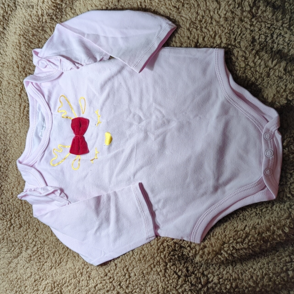 Cute pink holiday onesie with red bow and sleepy reindeer on front